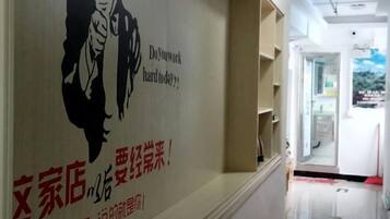 A corridor with a wall featuring a poster with text and a silhouette of a person.