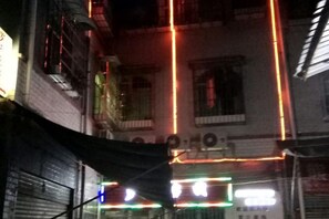 A building facade with multiple windows and a visible fire escape. - Fenggang Luosan Inn (Fenggang)