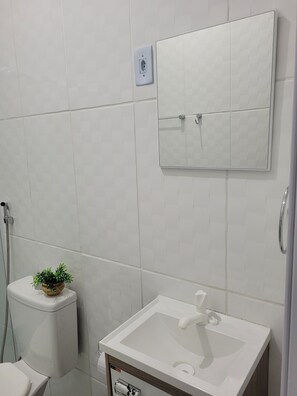 Chuveiro, toalhas de banho, sabonete, papel higiênico