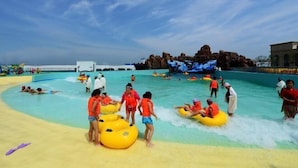 A water park with inflatable rafts, a pool, and a rocky backdrop. - Baodi Spring Town (Fuxin County)