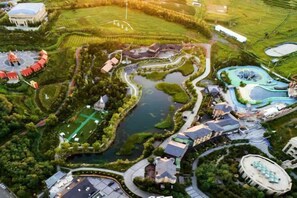 An aerial view of a resort with a central water feature, multiple buildings, and landscaped areas. - Baodi Spring Town (Fuxin County)