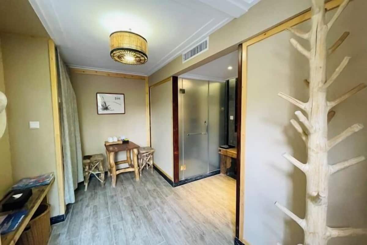 Ein Zimmer mit Holzboden, einem Esstisch mit Stühlen, einer Pendelleuchte und einer Schiebetür.