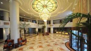A spacious lobby with a large chandelier, multiple seating areas, and a patterned floor. - Baodi Spring Town (Fuxin County)