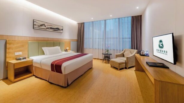 A hotel room with a bed, a desk, a chair, a TV, and a window with curtains. - Kailin International Hotel (Shenzhen Guangming Street subway station) (Shenzhen)