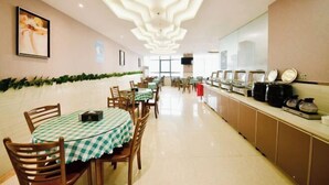 A restaurant with round tables, chairs, and a long counter with kitchen appliances. - Kailin International Hotel (Shenzhen Guangming Street subway station) (Shenzhen)