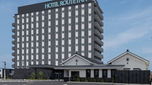 Ein mehrstöckiges Hotelgebäude mit einem Schild, auf dem 'HOTEL ROUTE INN' steht.