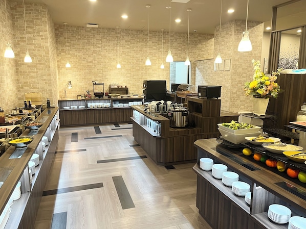 A buffet-style breakfast area with multiple serving stations, a brick wall backdrop, and pendant lighting. - Hotel Route Inn Tokushima Airport -Matsushige smart inter- (Matsushige)