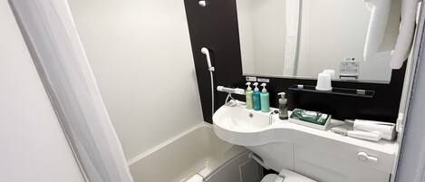 A modern bathroom with a white sink, mirror, and toilet. There are toiletries on the sink and a towel hanging on the wall.