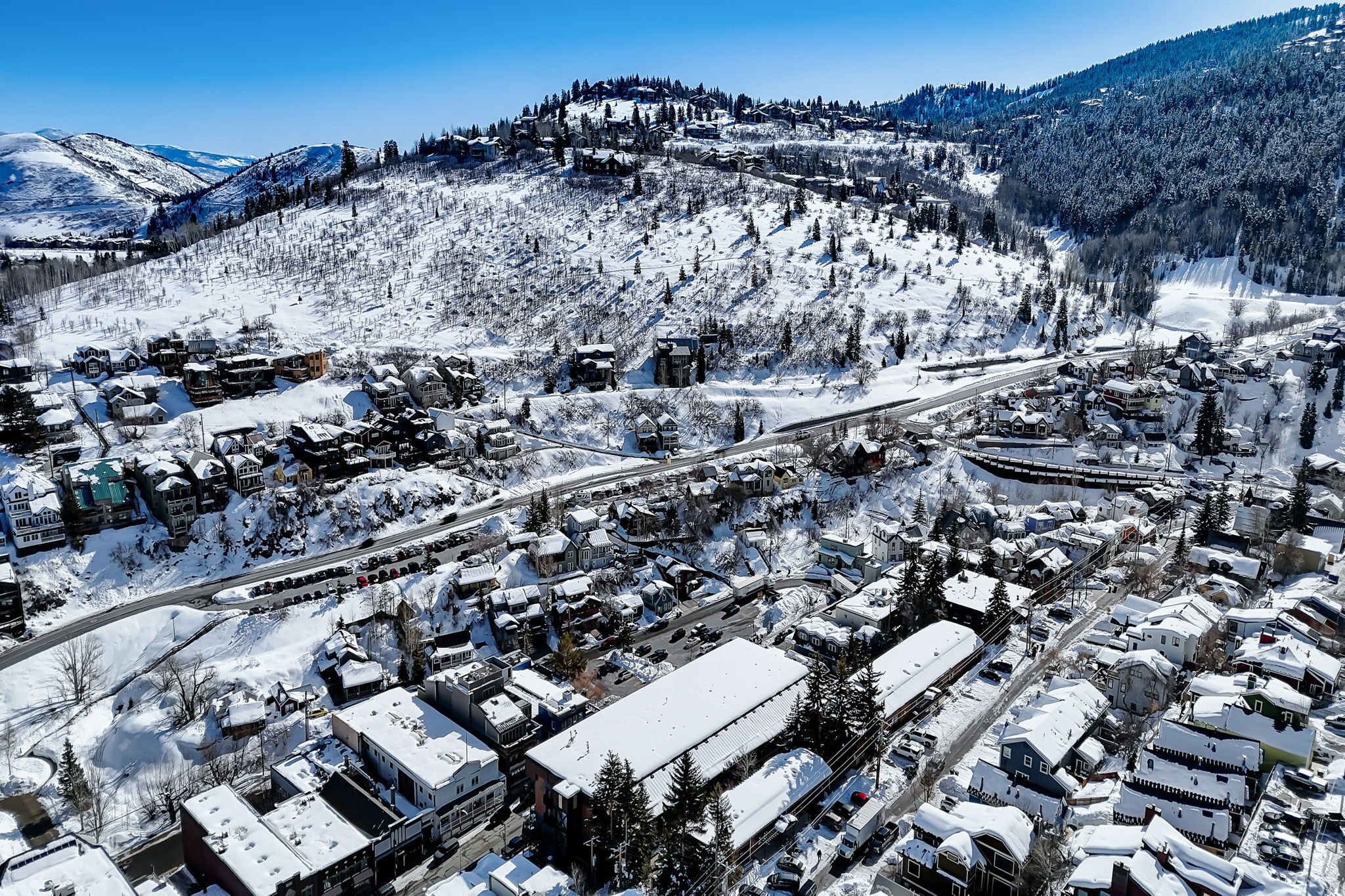 Un pueblo cubierto de nieve con edificios y una montaña al fondo.
