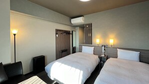 A hotel room with two beds, a desk, a chair, a lamp, and a mirror. - Hotel Route Inn Miyakonojo (Miyakonojo)