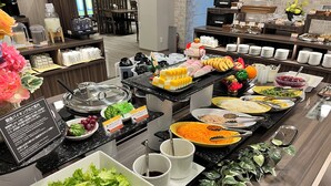 A buffet setup with various food items and condiments. - Hotel Route Inn Miyakonojo (Miyakonojo)