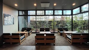 A modern conference room with large windows, wooden furniture, and a tiled floor. - Hotel Route Inn Miyakonojo (Miyakonojo)
