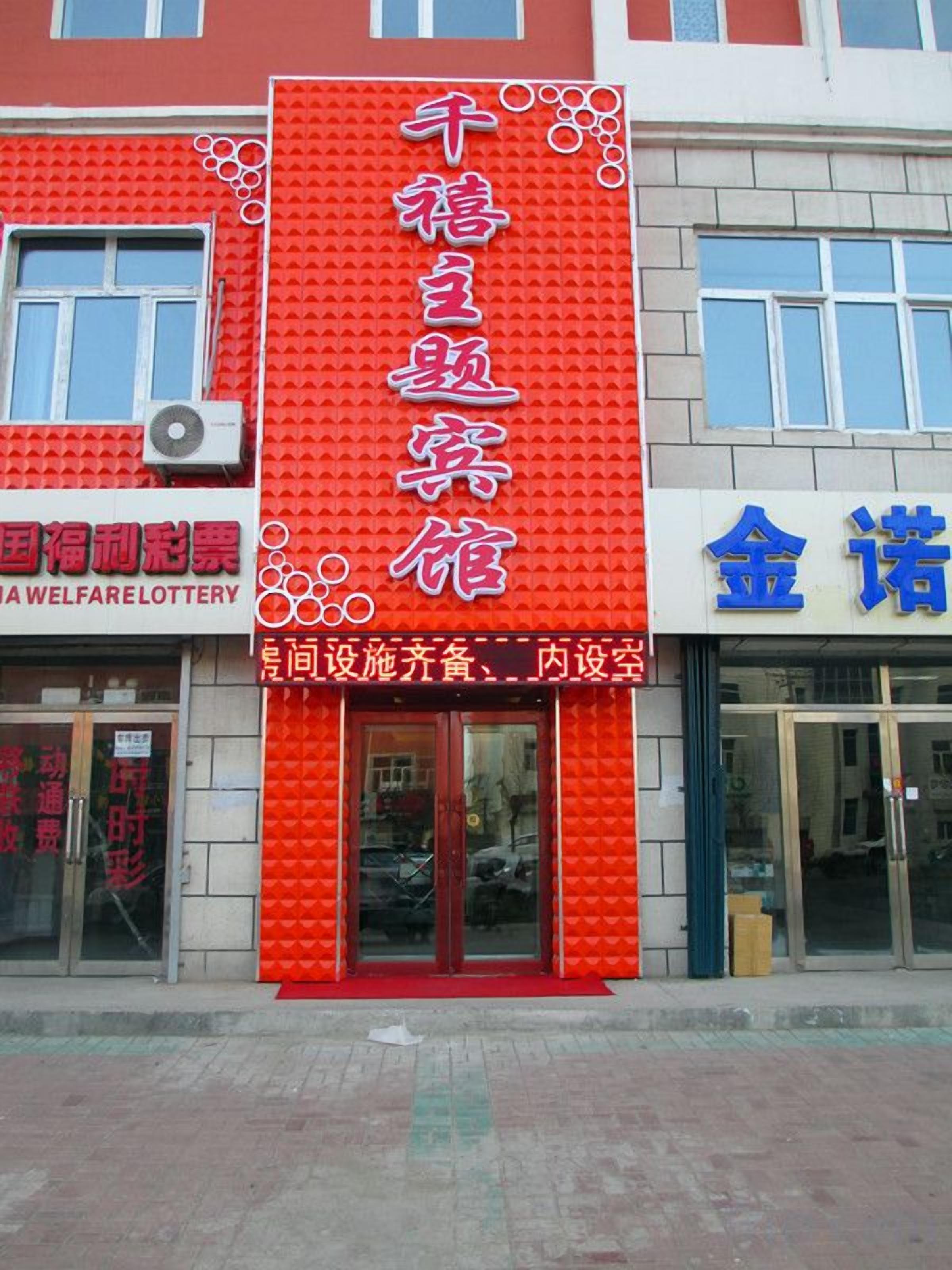 A building with a prominent red sign and a blue sign on the right.