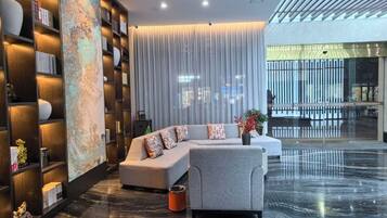 A modern living room with a sectional sofa, a coffee table, and a bookshelf.