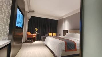 A modern hotel room with a large bed, a desk with a chair, a television, and a view of the city.