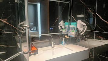 Un baño moderno con un espejo grande, dos lavamanos y una zona de tocador.