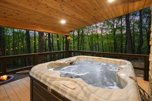 A hot tub on a wooden deck with a forest view. - Uckor's Cottage | Hocking Hills, 5 Acres, Hot Tub (Rockbridge)