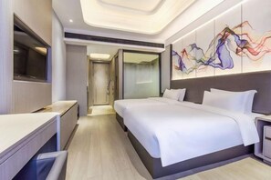 A modern hotel room with a large bed, a desk, and a television. - Yueyang Kaibinsi Holiday Hotel (Yueyang)