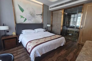Una habitación de hotel con una cama grande, una mesita de noche, una lámpara, un cuadro en la pared y un armario con puerta corredera.