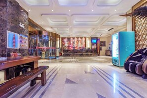 A hotel lobby with a reception desk, a vending machine, and a seating area. - Yueyang Kaibinsi Holiday Hotel (Yueyang)