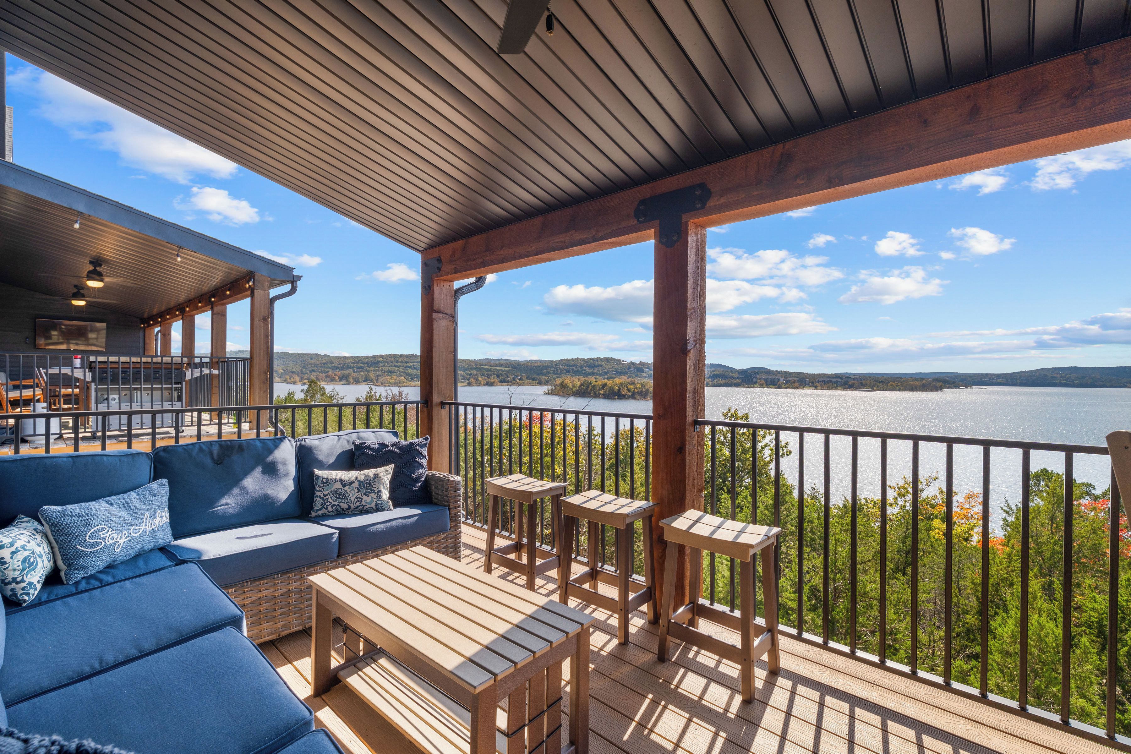 A covered outdoor seating area with a view of a lake.