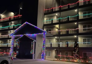 Ein mehrstöckiges Gebäude mit Balkonen, die mit bunten Lichterketten geschmückt sind.