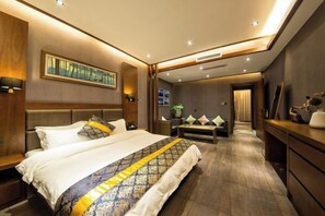Una habitación de hotel moderna con una cama grande, mesitas de noche, un escritorio y un espejo.