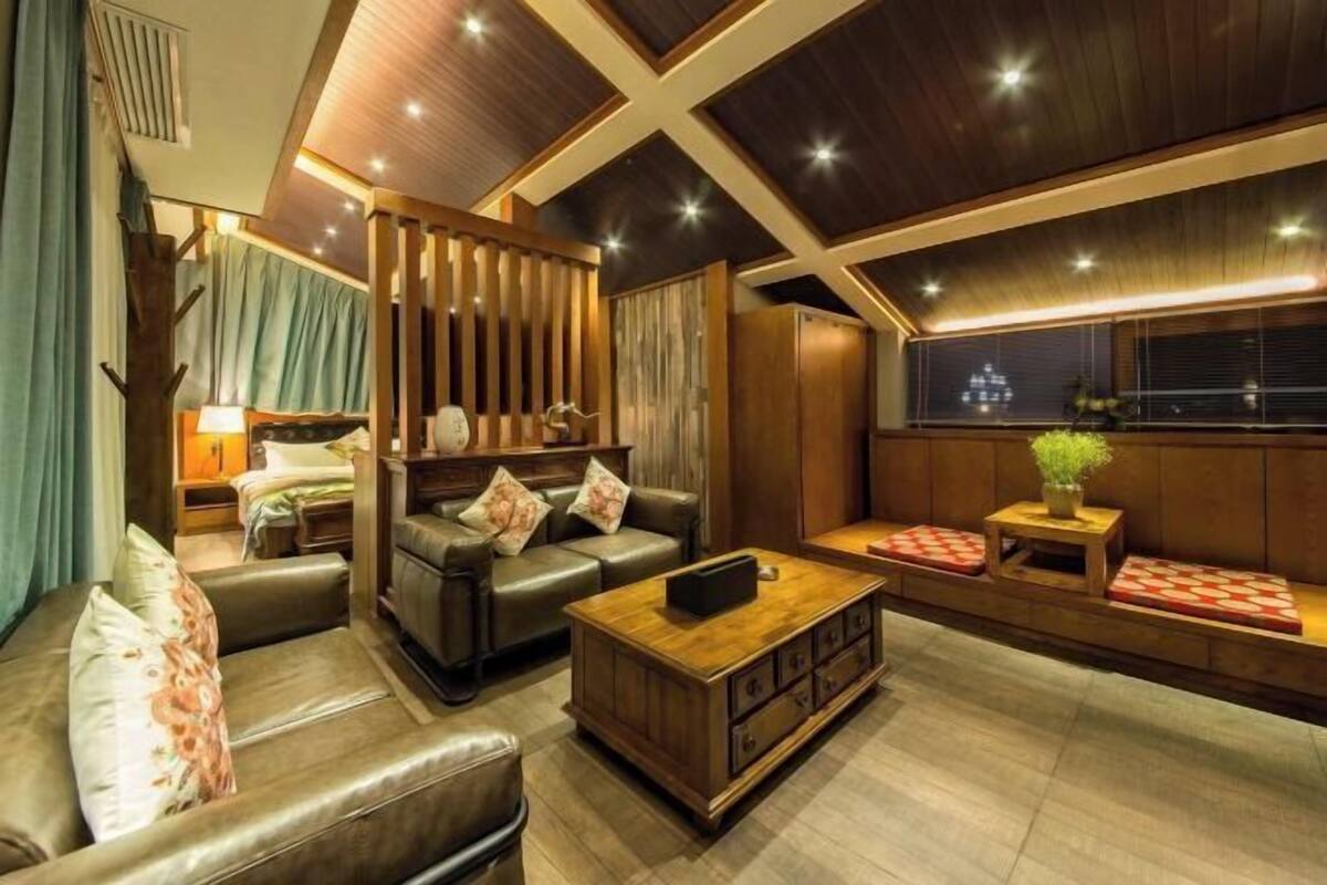 A modern living room with a sofa, coffee table, and a seating area with cushions.