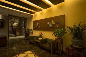 A lobby with a staircase, seating area, and a wall-mounted artwork. - Chengli Chengwai Inn (Lijiang)