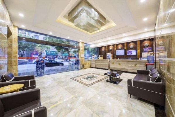 A hotel lobby with a reception desk, seating area, and a large window overlooking the street. - Xinyuan Hotel (Xiushan Bus Terminal) (Xiushan County)