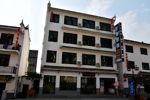 Edifici d'edifici amb un estil arquitectònic tradicional, amb una entrada central amb tenda i un taulell informatiu a dalt.