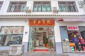 Una fachada con un letrero que dice 'Zhonghua Supermarket' y un escaparate con productos.