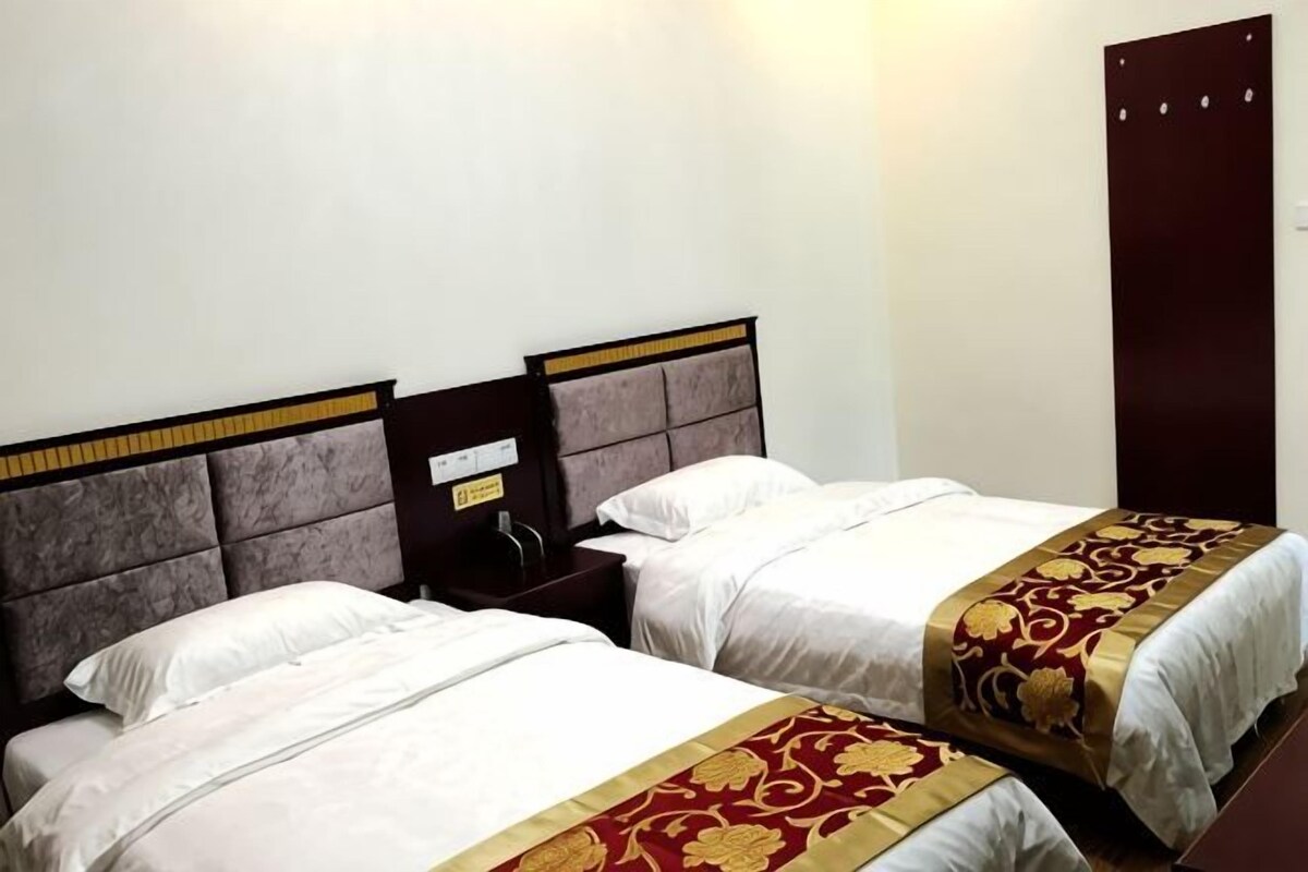 Two beds with headboards, a nightstand, and a wardrobe.