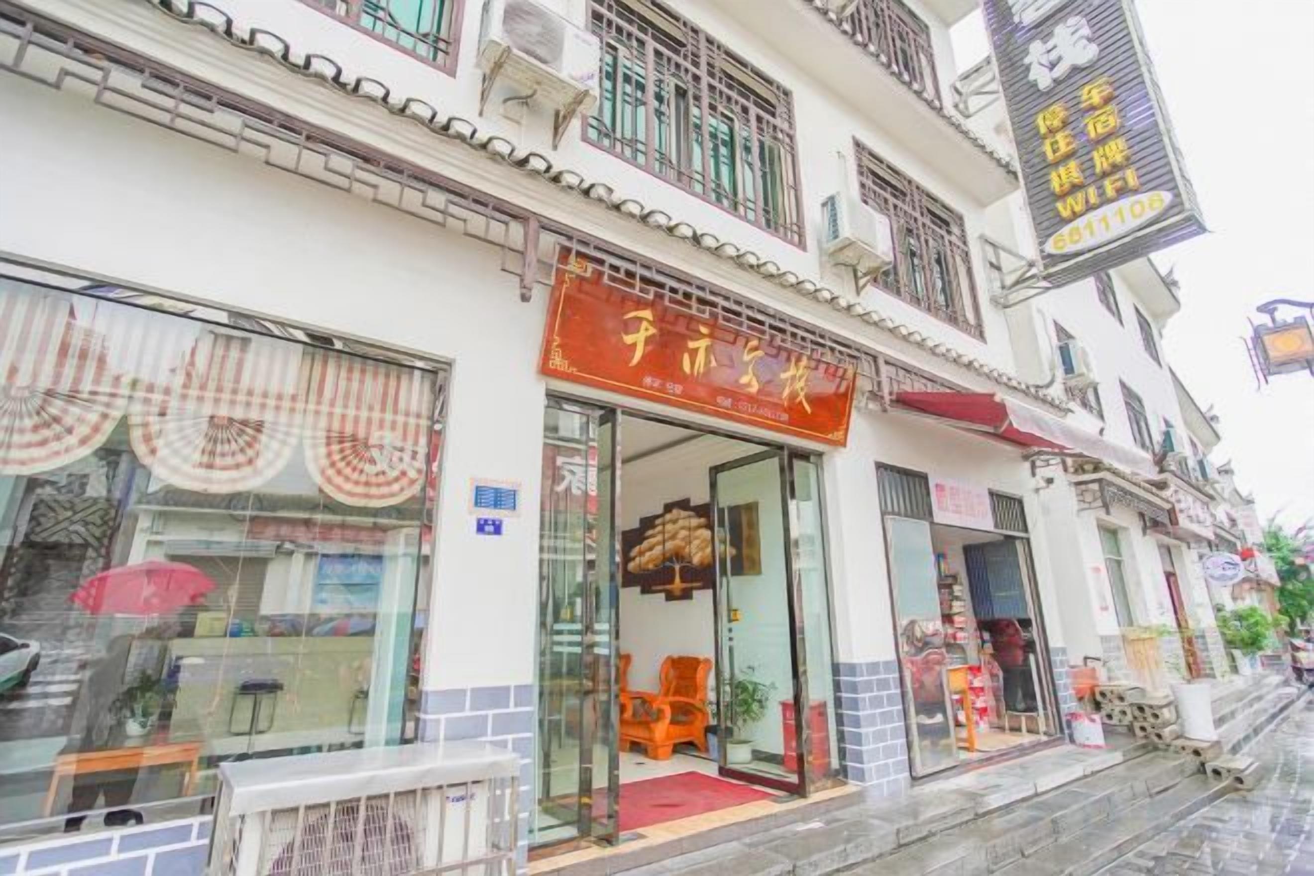 A traditional building with a storefront featuring a red sign.