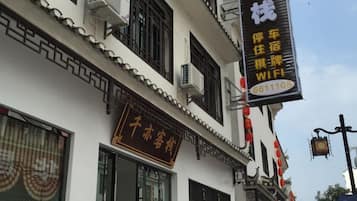 A building with traditional Chinese architectural elements, including ornate window frames and a signboard with Chinese characters.