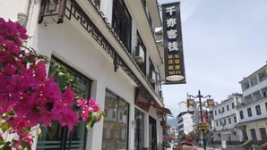 A street view with a building featuring a signboard advertising WiFi and a contact number. - Qianyi Inn (Yichang)