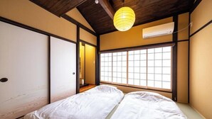 A traditional Japanese-style room with tatami flooring, a sliding shoji door, and a large window with a view of the outside. - Kyoto 11 Inn Shimabara (Kyoto)