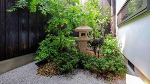 A garden with a stone lantern, various plants, and a wooden fence. - Kyoto 11 Inn Shimabara (Kyoto)