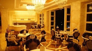A hotel lobby with a reception desk, multiple dining tables, and chairs. - Shanhai Holiday Resort (Haikou)