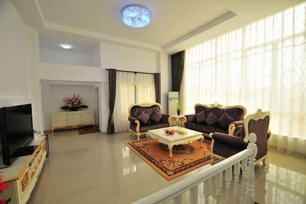 A living room with a sofa set, a coffee table, a TV, and a decorative rug.