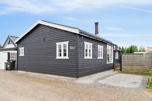 A two-story house with a dark exterior, white trim, and a chimney. - Holiday home close to the beach and restaurants (Karrebæksminde)