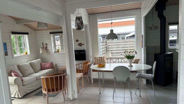 Une pièce confortable avec un canapé, une table à manger, des chaises et un téléviseur.