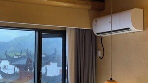 Una stanza con una grande finestra, un condizionatore d'aria a parete e un lampadario.