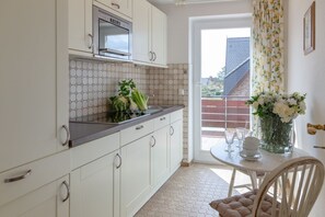 Fridge, stovetop, coffee/tea maker, electric kettle - NEU 2024 - Ferienwohnung Bravo - Urlaubstraum mit Weitblick: Ferienwohnung im OG mit Großem Balkon (Wenningstedt-Braderup (Sylt))