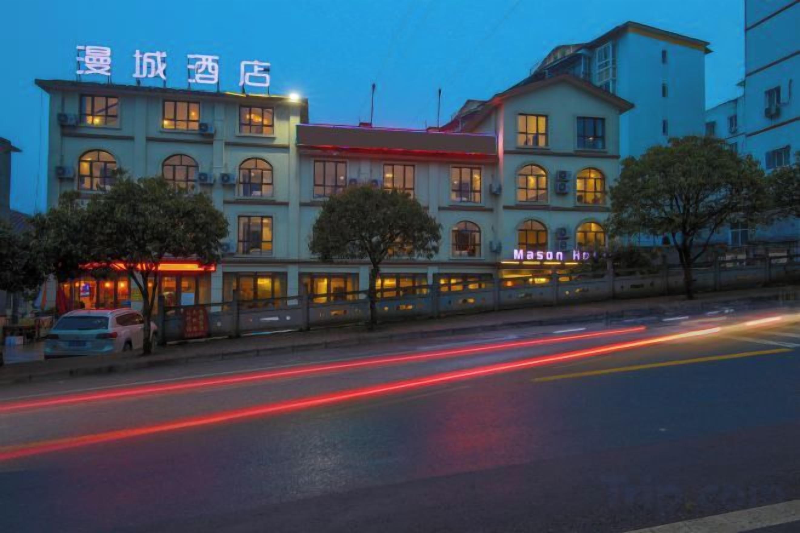 Um hotel com vários andares, uma placa de destaque e uma rua em primeiro plano.