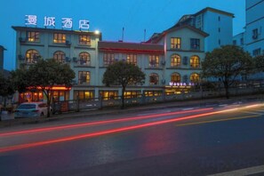 A hotel with multiple floors, a prominent sign, and a street in the foreground. - Mason Hotel (Chongqing)