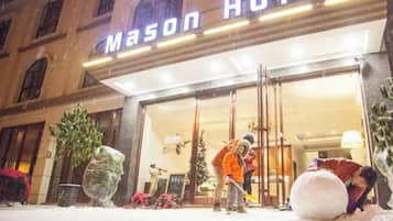 Een hotelingang met een bord waarop 'Mason Hotel' staat.