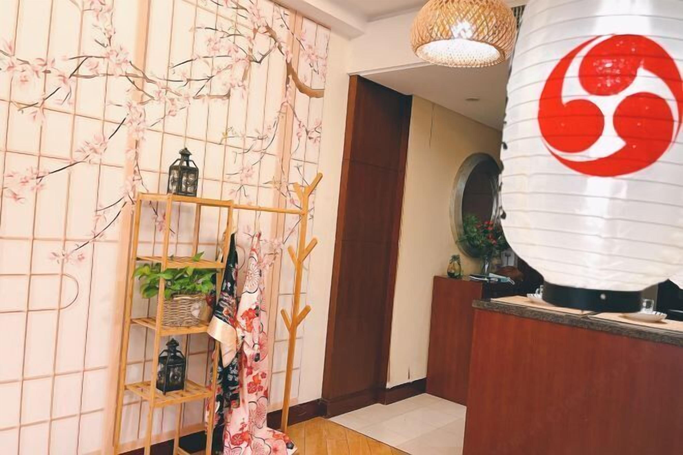 Zona de recepción con un escritorio de madera, un farol colgante y una pared con diseño floral.