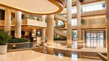 A multi-level atrium with a central spiral staircase, large windows, and a reception area.