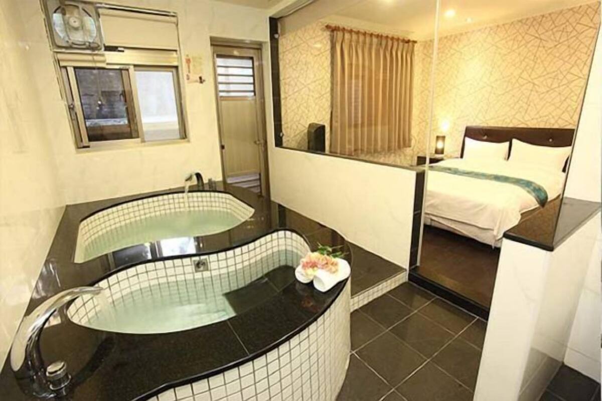 Une salle de bain moderne dotée d’une grande baignoire, d’une douche séparée et d’un lit offrant une vue sur la ville.